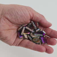 Video of Flip ceramic puzzle pieces in rainbow colors, opaque glazed porcelain, 4–20 mm, held in a hand and poured out to show their shapes and finish
