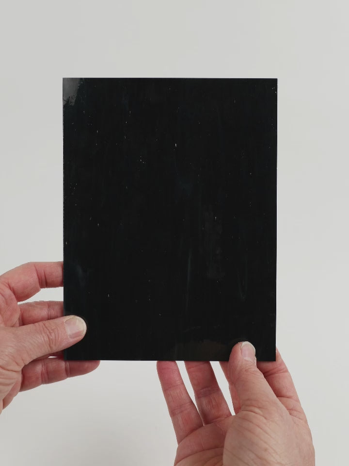 Video of the Smoking Embers glass plate in black, opaque, 15x19cm, held up and tilted to show its pattern and transparency.