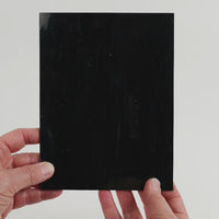 Video of the Smoking Embers glass plate in black, opaque, 15x19cm, held up and tilted to show its pattern and transparency.