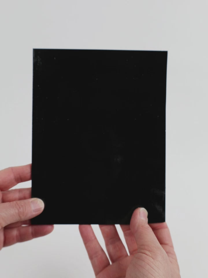 Video of the Pure black glass plate in black and opaque, 15x19cm, held up and tilted to show its pattern and transparency.