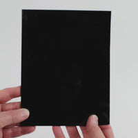 Video of the Pure black glass plate in black and opaque, 15x19cm, held up and tilted to show its pattern and transparency.